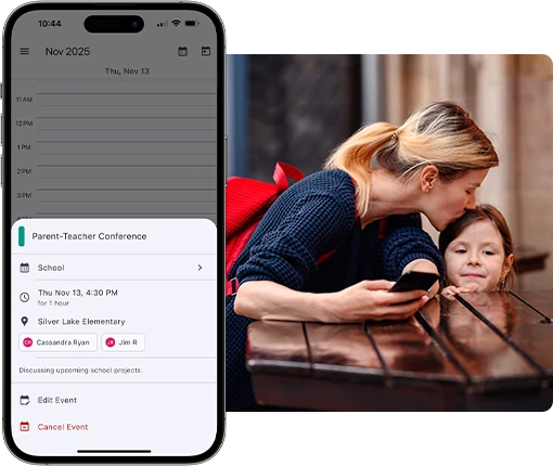 Mother sitting with her daughter outdoors while reviewing a parent teacher conference event on the Parent Link shared custody calendar displayed on a smartphone.